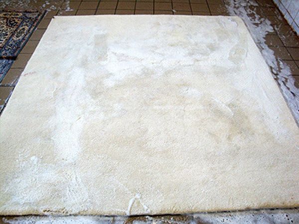 Ein weißer Teppich liegt auf einem gefliesten Boden