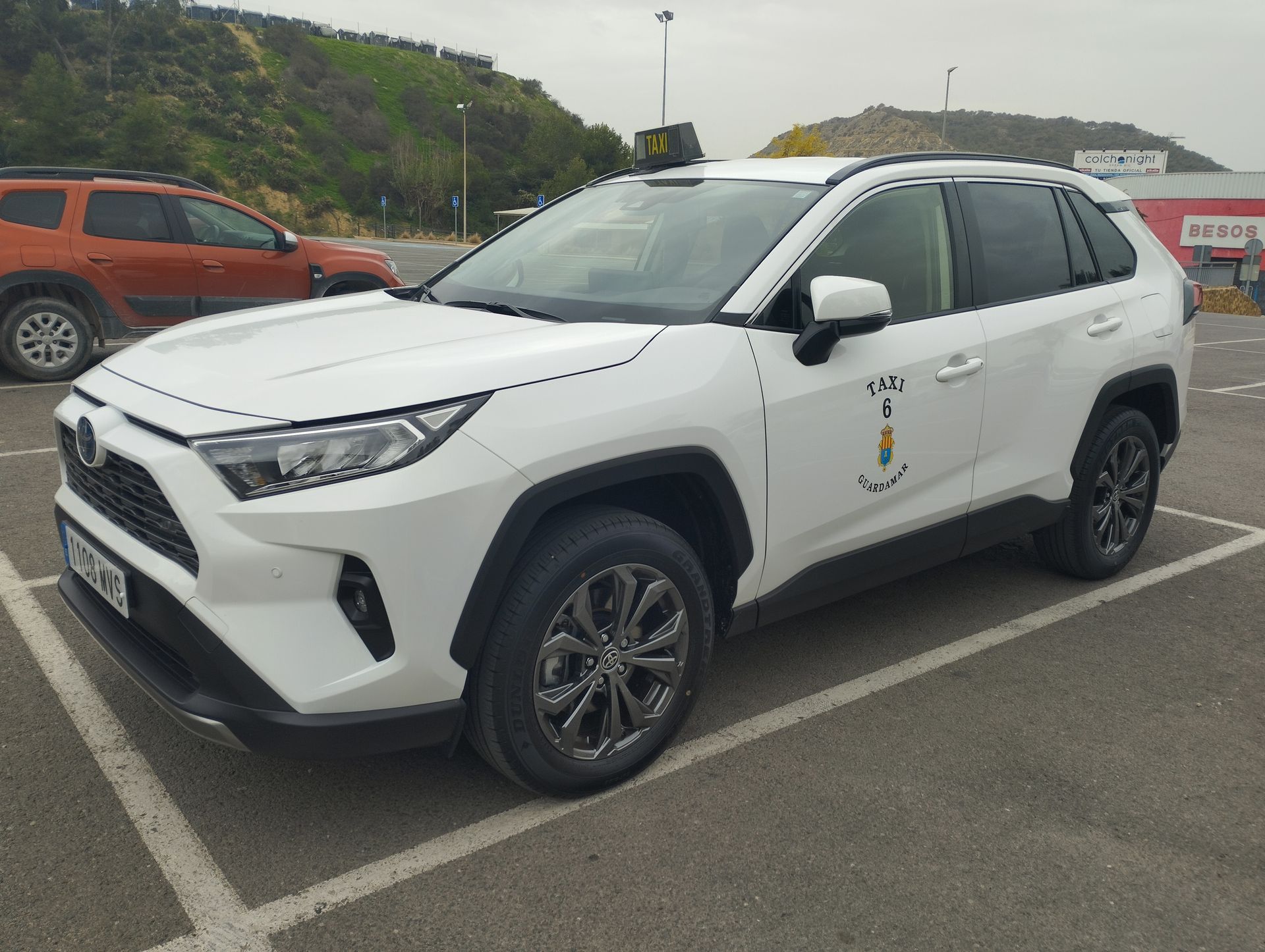 Una camioneta blanca está estacionada en un estacionamiento.
