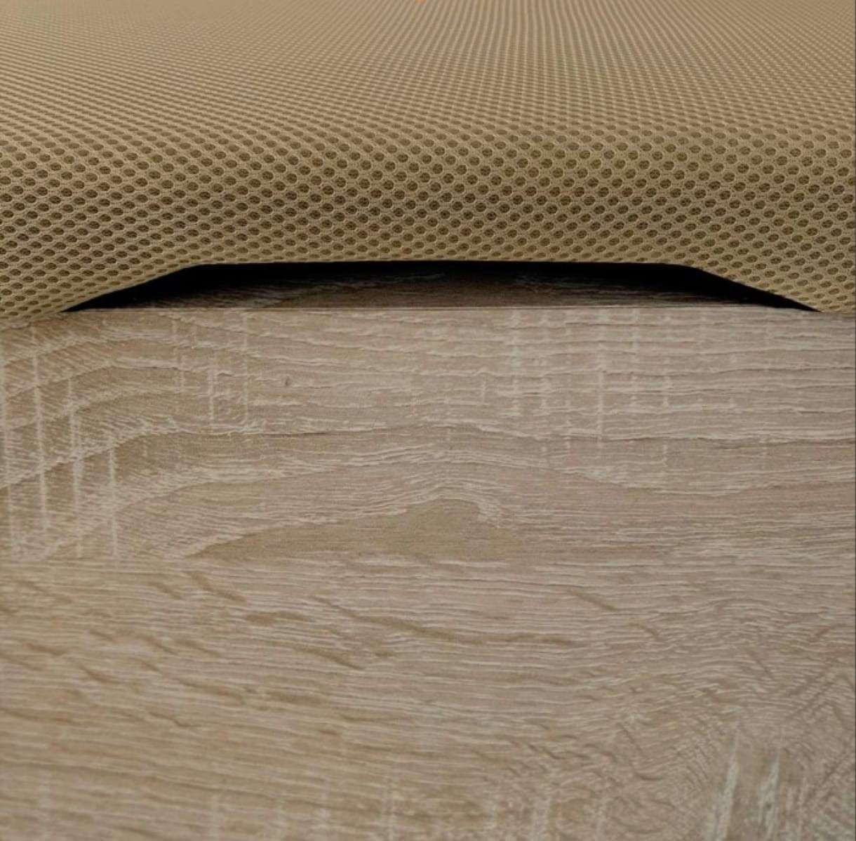 Primer plano del borde de un cojín de tela texturizada de color tostado