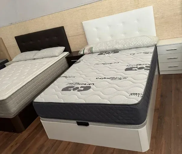 Dos camas individuales con cabeceros y bases con espacio de almacenamiento