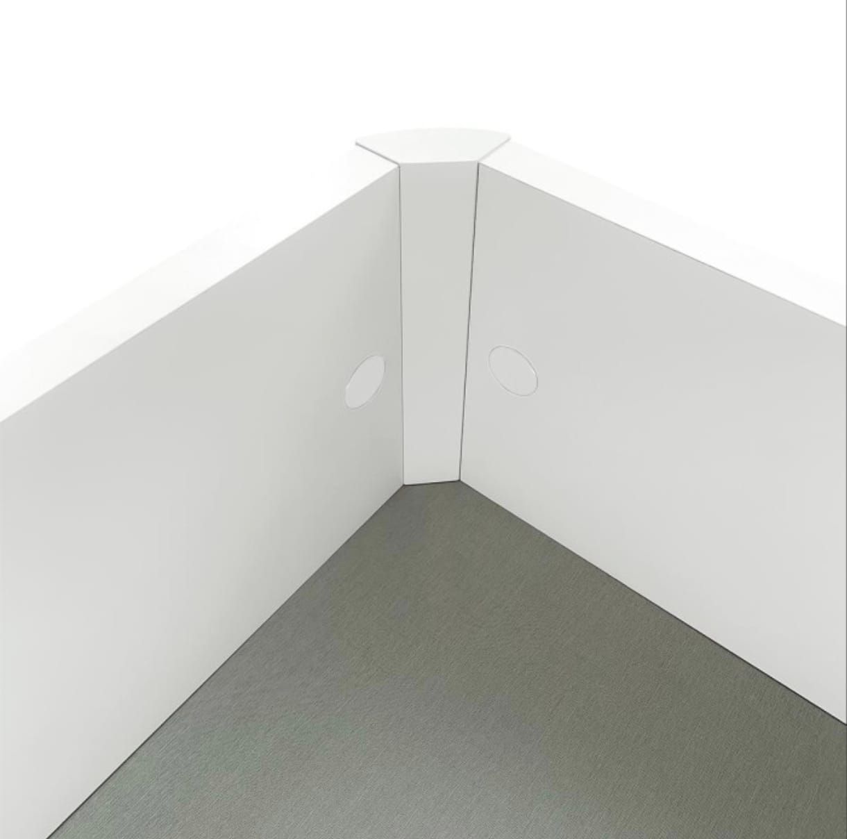 Un conector de esquina blanco une dos paneles blancos perpendiculares sobre una superficie gris.