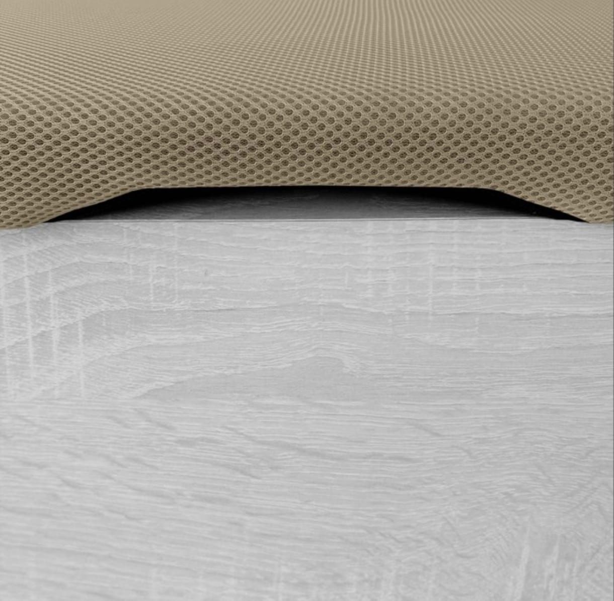 Un cojín de tela texturizada de color beige está colocado