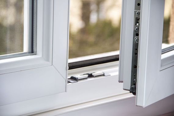 Gros plan sur un loquet blanc de fenêtre à guillotine ouverte