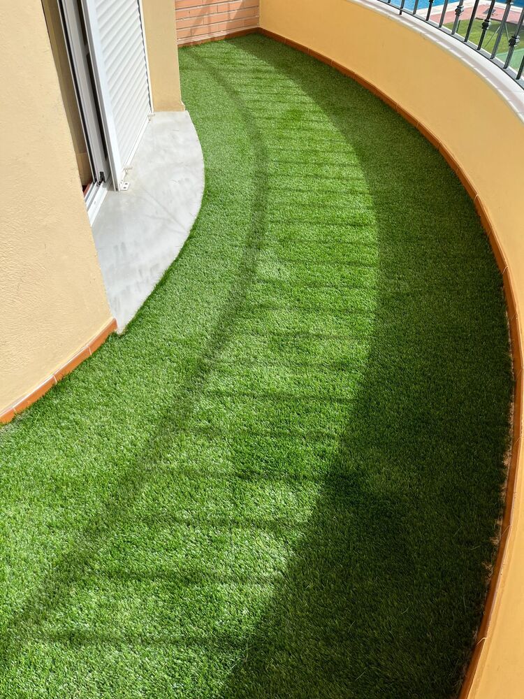 Un balcón con mucho césped verde.