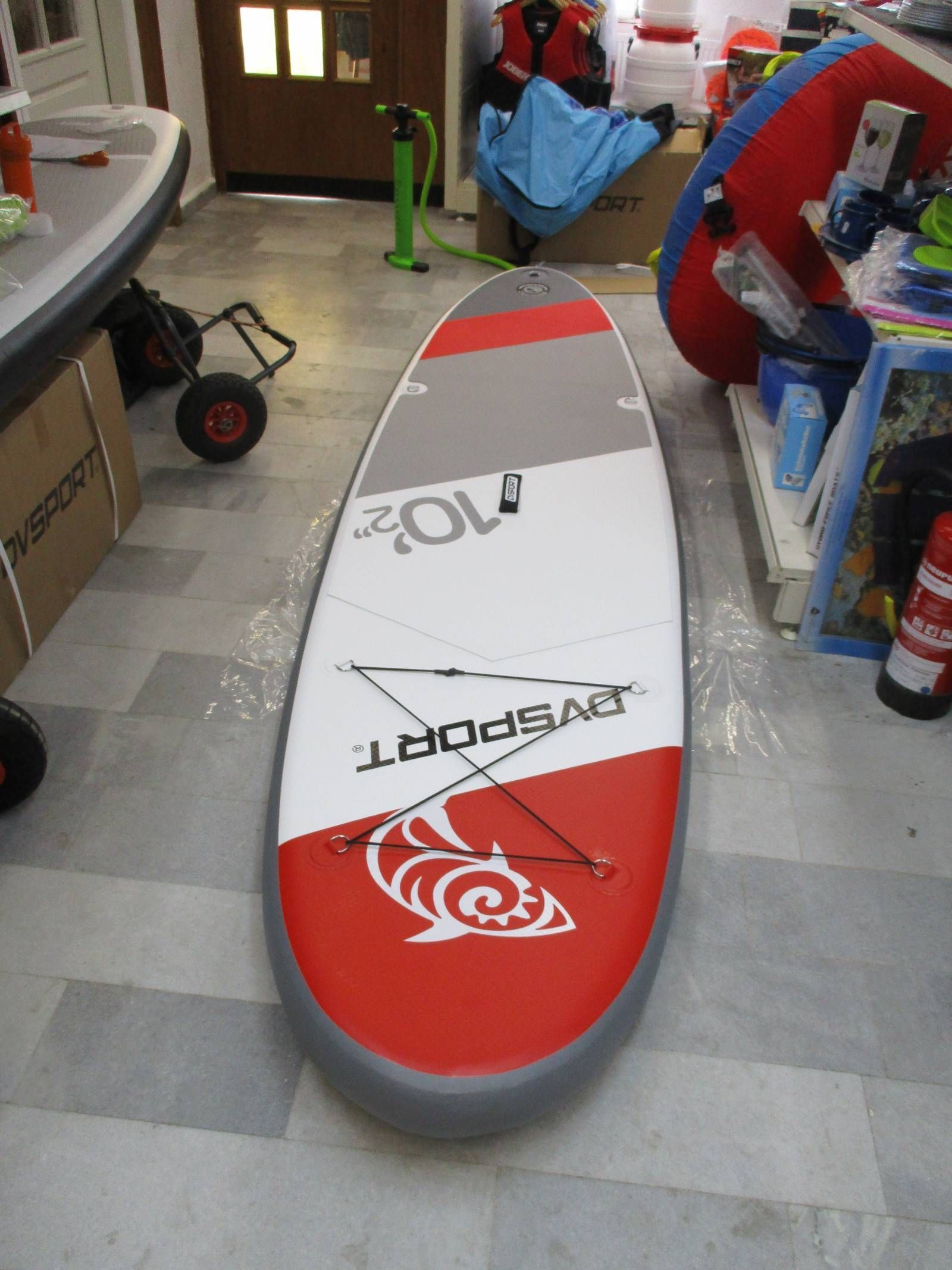 Ein rot-weiß-graues Surfbrett mit dem Wort „Sport“ darauf