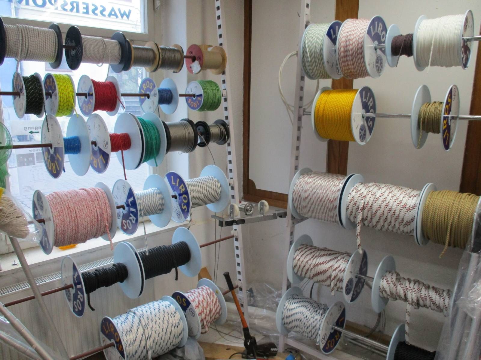 In einem Raum hängt ein Bündel Seilrollen auf einem Gestell.