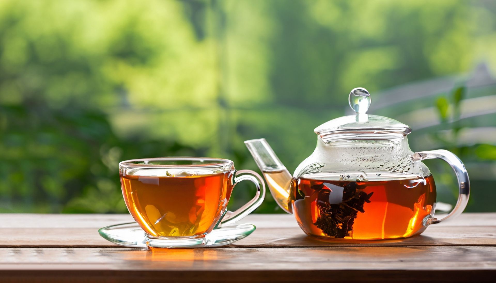 Deux tasses de thé ambré sur une table en bois près d'une fenêtre ensoleillée