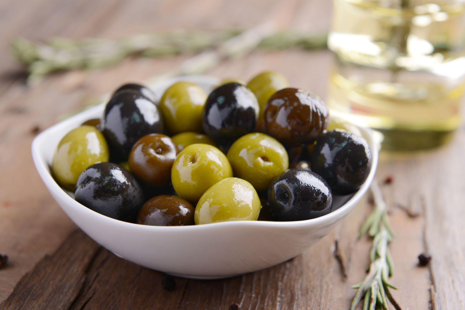 Bol d'olives noires et vertes mélangées sur une table en bois rustique