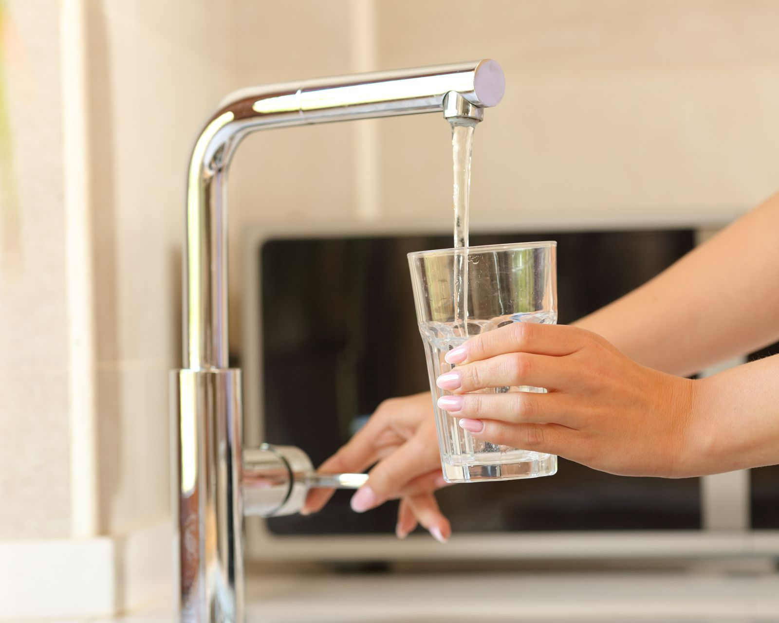 Une femme se sert un verre d'eau