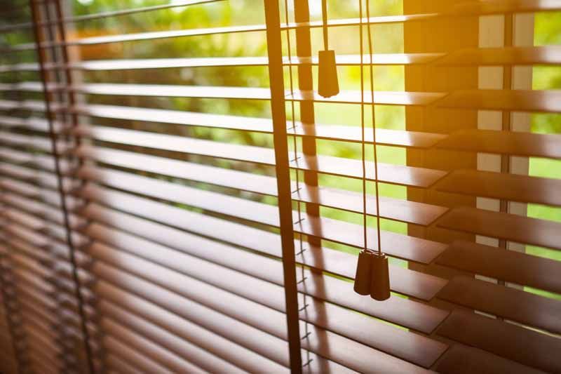 La lumière du soleil à travers les stores à cordons pendants
