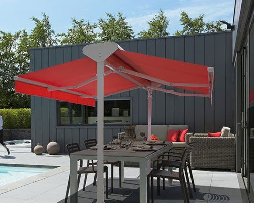 Terrasse arrière avec parasol rouge déporté au-dessus de la table à manger et sièges extérieurs au bord de la piscine