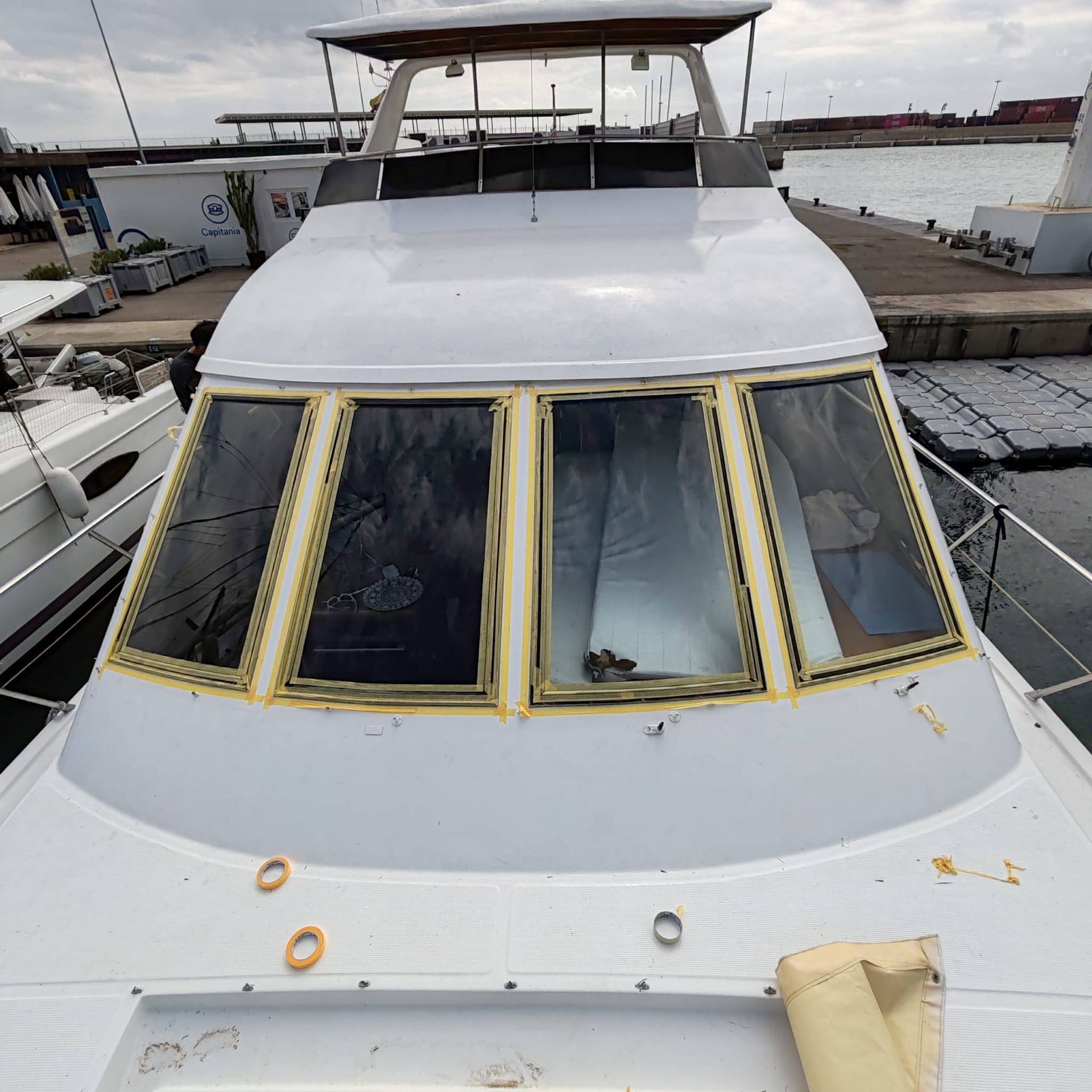 Barco blanco con ventanas selladas en un puerto.