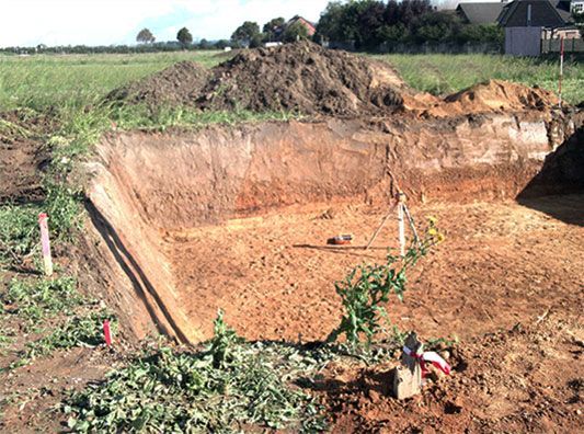 Mitten auf einem Feld liegt ein großer Erdhaufen.