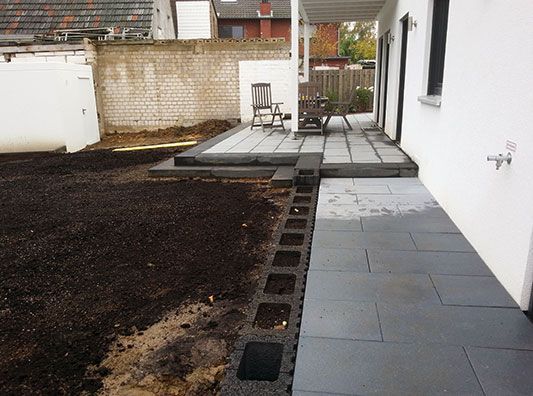 Im Hinterhof eines Hauses wird eine Terrasse gebaut.