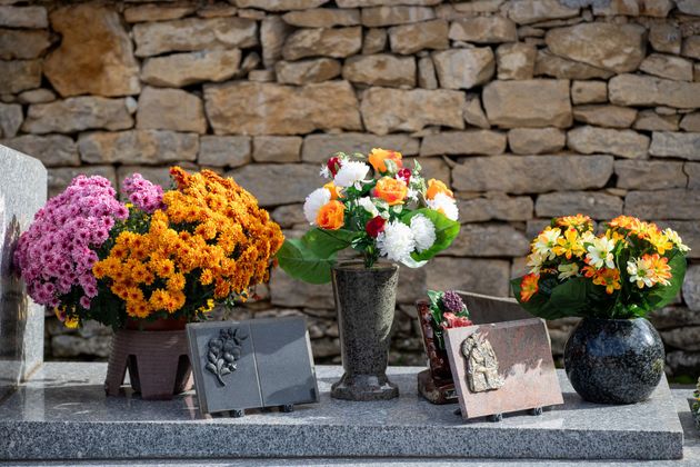 Plusieurs articles funéraires posés sur une surface en marbre dans un cimetière