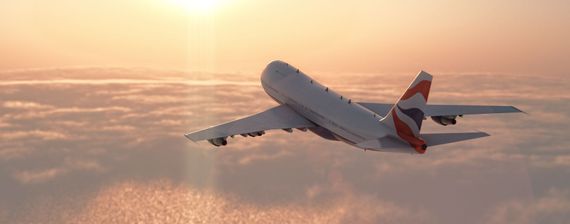 Un avion survole les nuages au coucher du soleil, sous un ciel orangé chaleureux