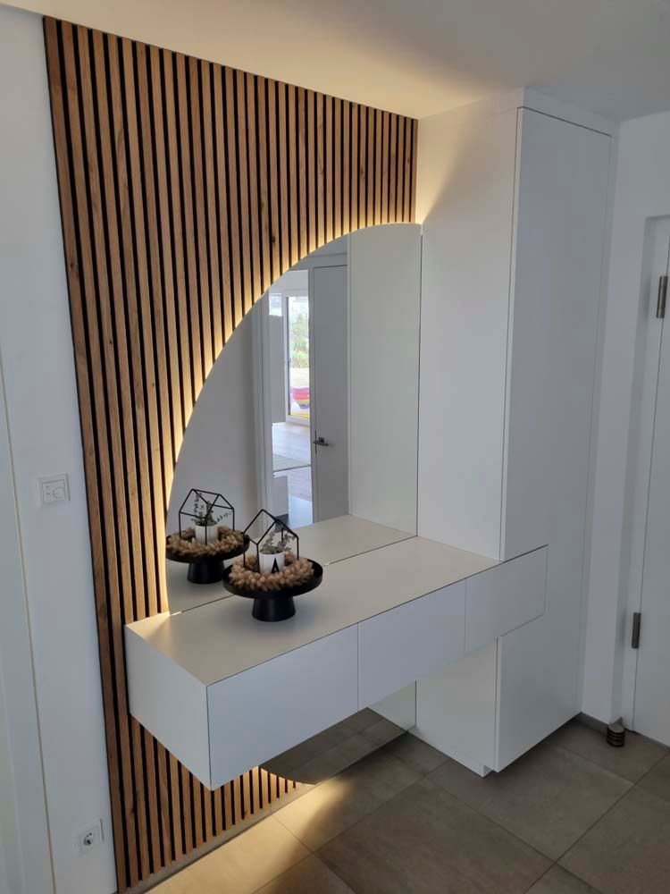 Ein Flur mit Spiegel und Holzwand.