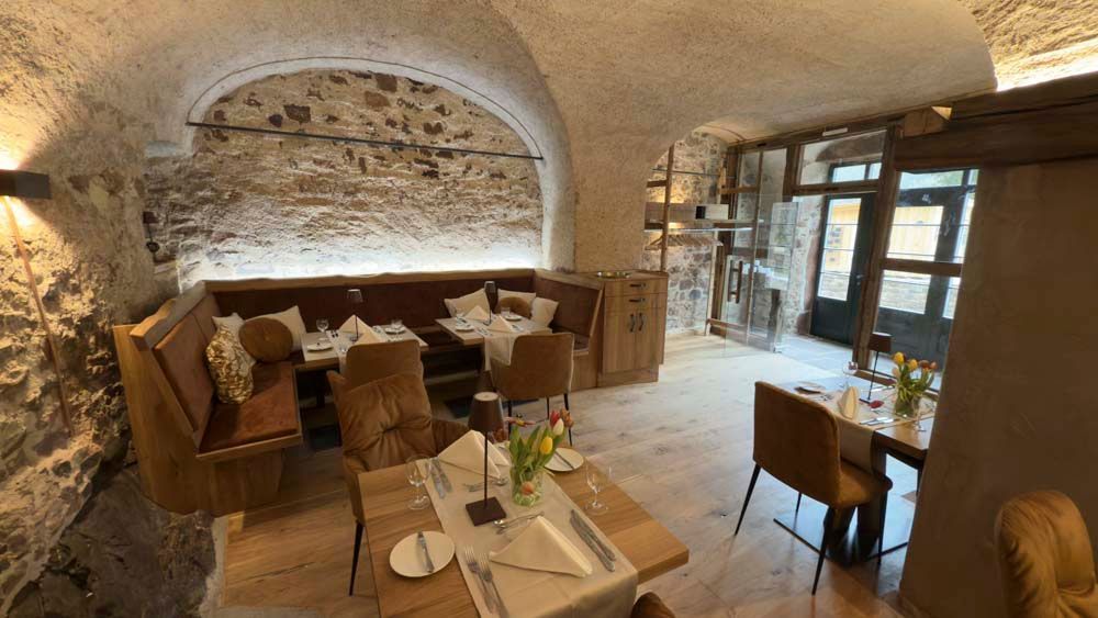 Ein Restaurant mit Tischen und Stühlen und einer Backsteinwand.