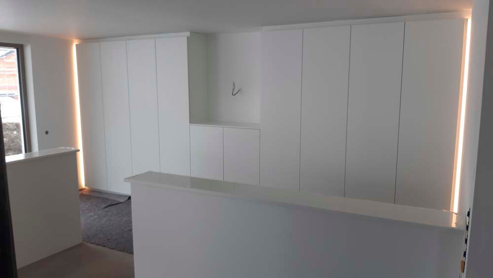 Ein Raum mit weißen Schränken und einer Lampe an der Wand.