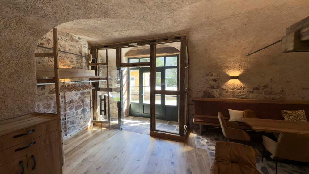 Ein Wohnzimmer mit Holzboden, einer Couch, einem Tisch und Stühlen.