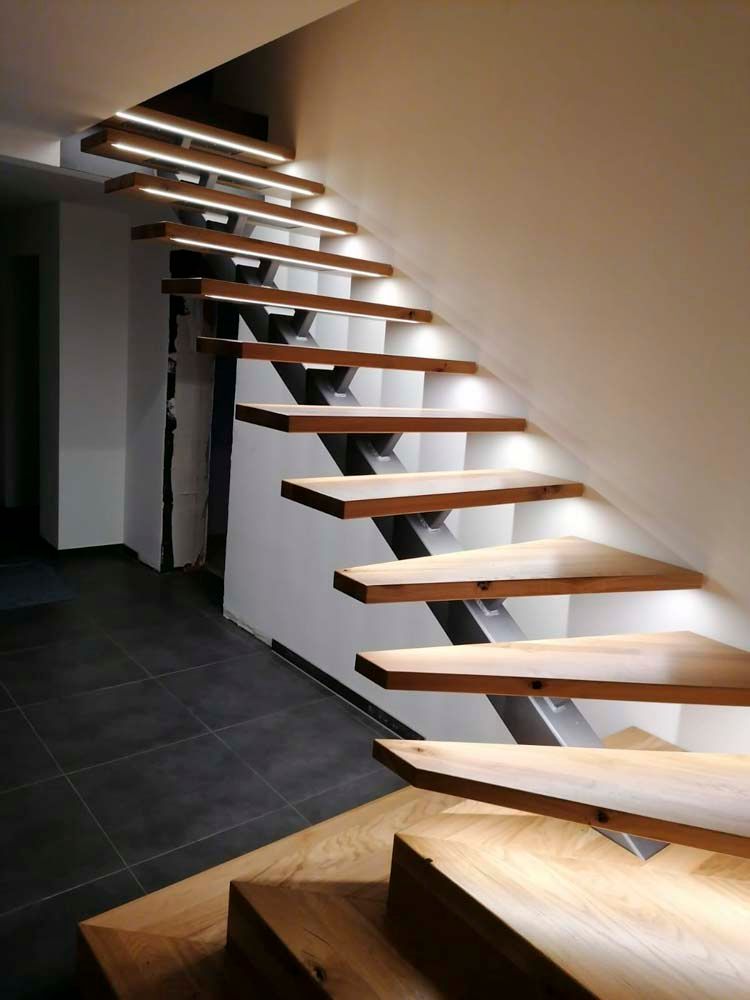 Eine Holztreppe mit Lichtern auf den Stufen in einem Flur.