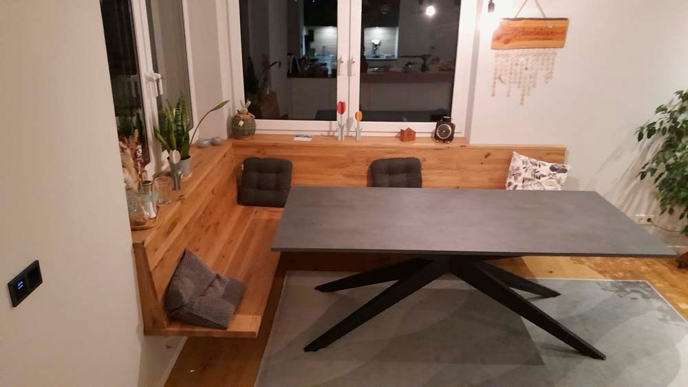 Ein Esszimmer mit einem Tisch und einer Bank unter einem Fenster.