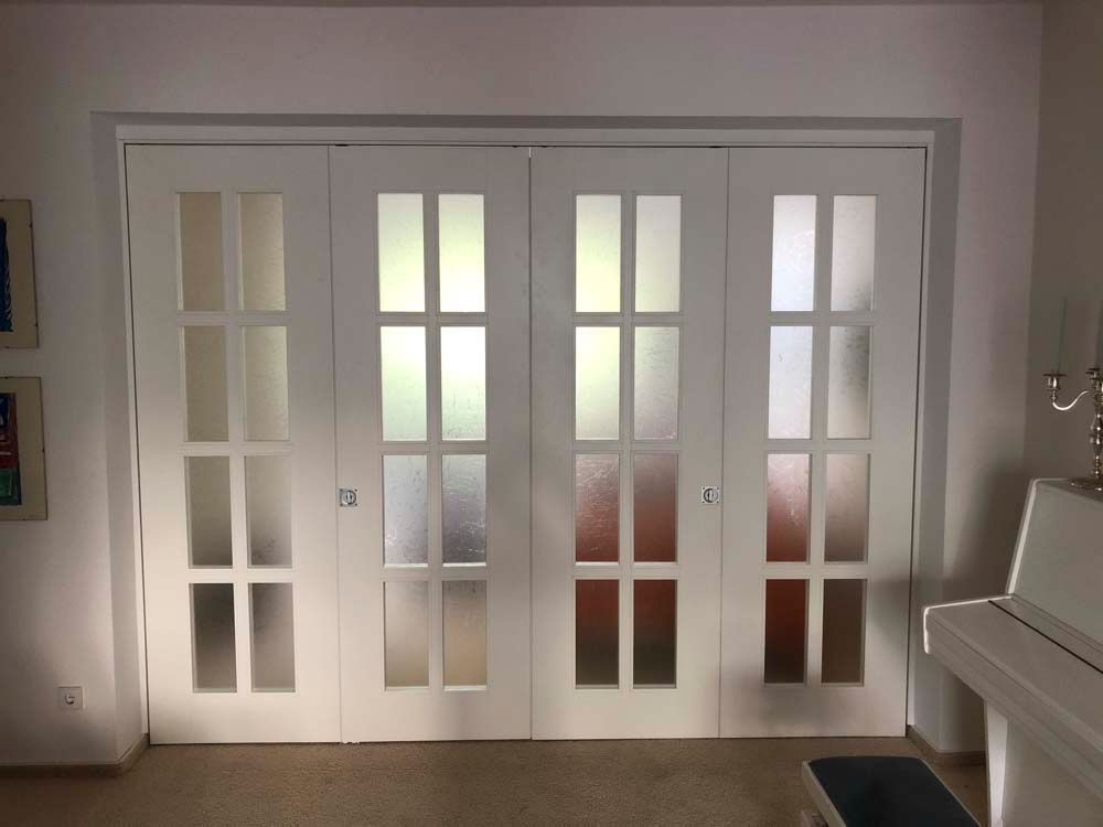 Ein Raum mit einem Klavier und Glasschiebetüren