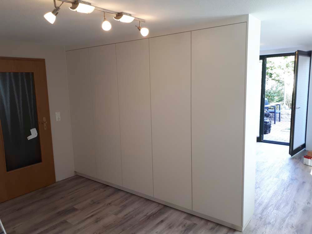 Ein Raum mit einer Glasschiebetür und weißen Schränken.