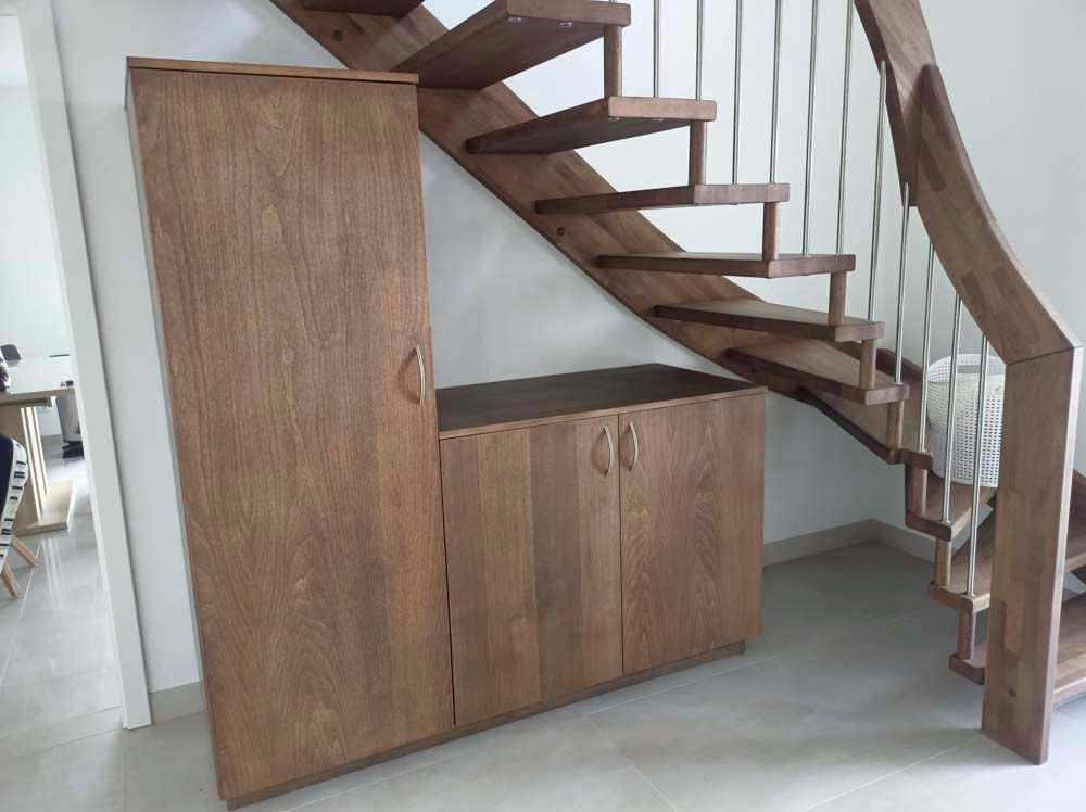 Eine Holztreppe mit einem Schrank darunter.