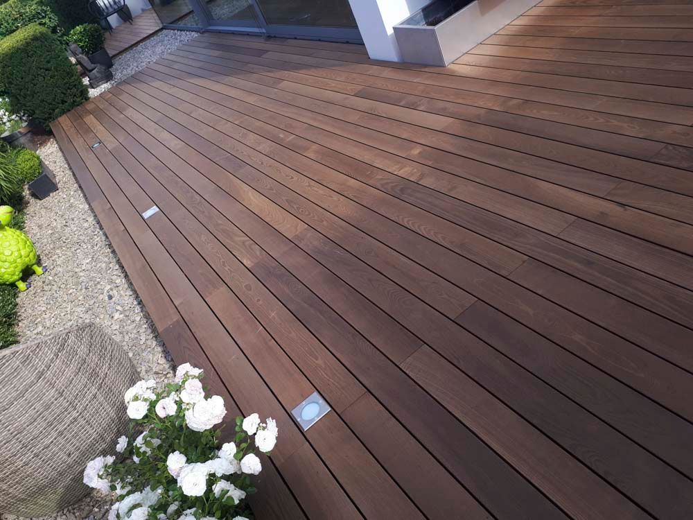Ein Holzdeck mit weißen Blumen darauf