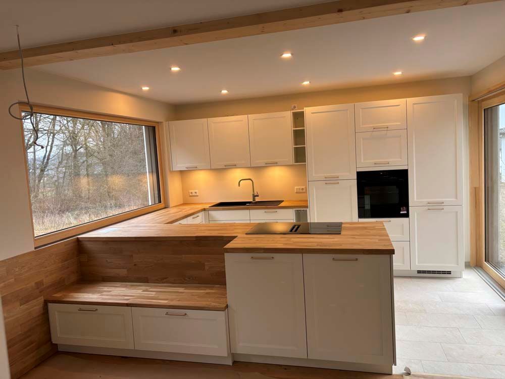 Eine Küche mit weißen Schränken und Holzarbeitsplatten.