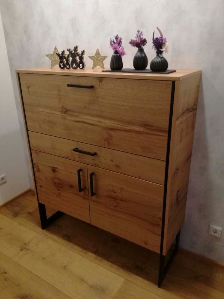 Eine Holzkommode mit Blumen und Sternen darauf