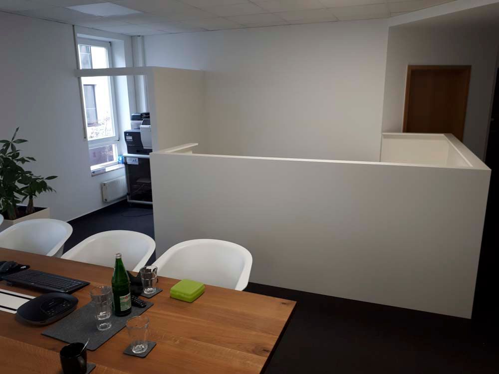 Ein Raum mit einem Holztisch und weißen Stühlen