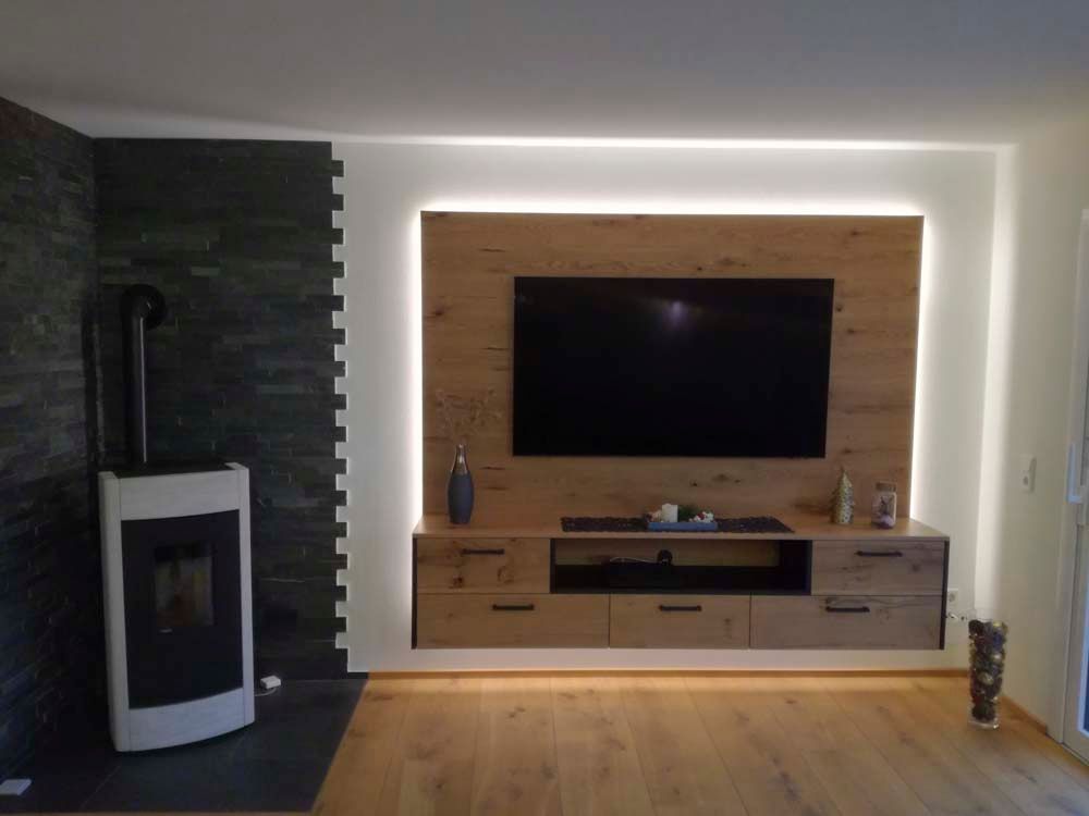 Ein Wohnzimmer mit Kamin und einem Flachbildfernseher an der Wand.