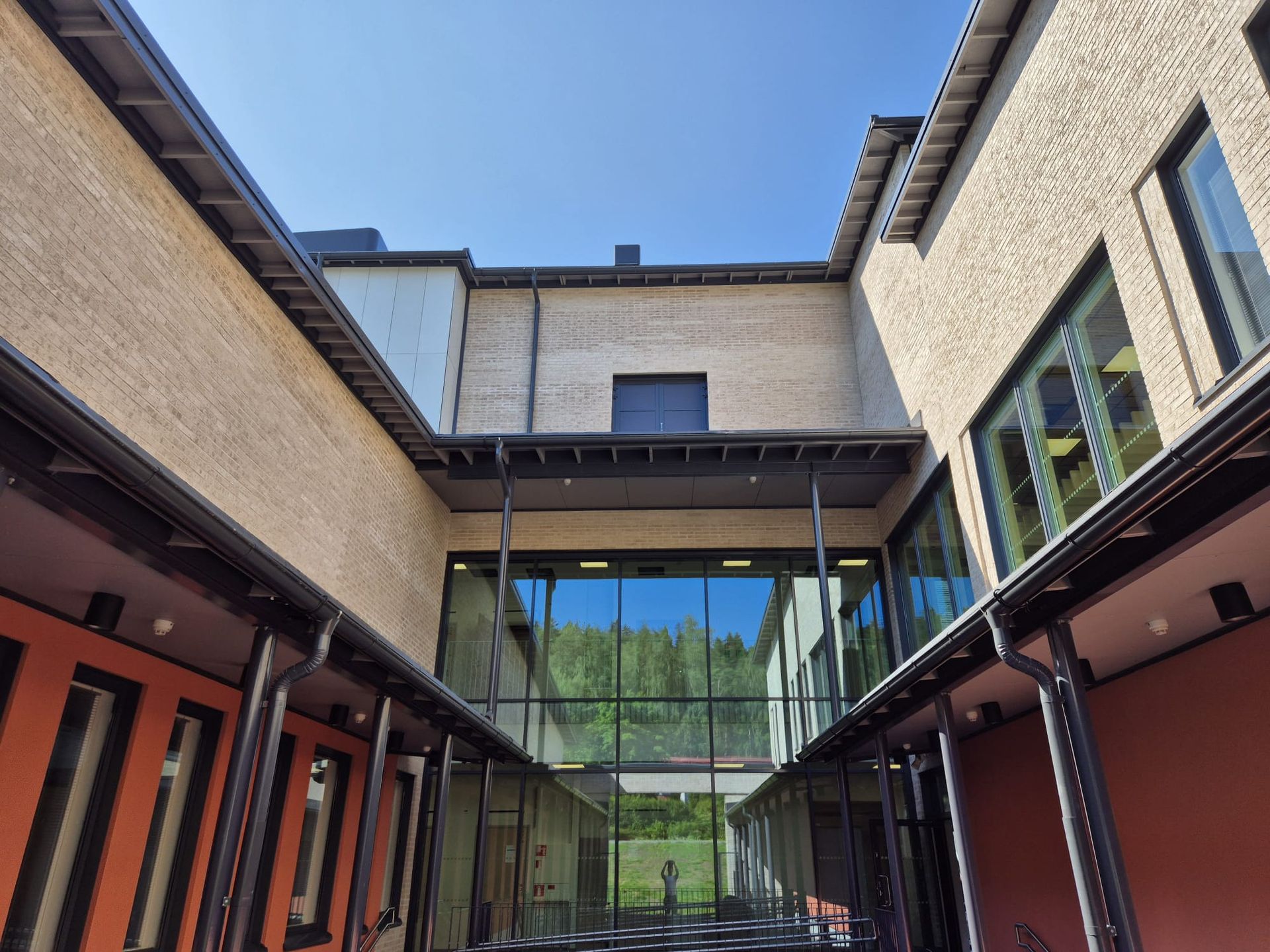 Modernin rakennuksen sisäpihan peltityöt ja sadevesijärjestelmät asennettuna.