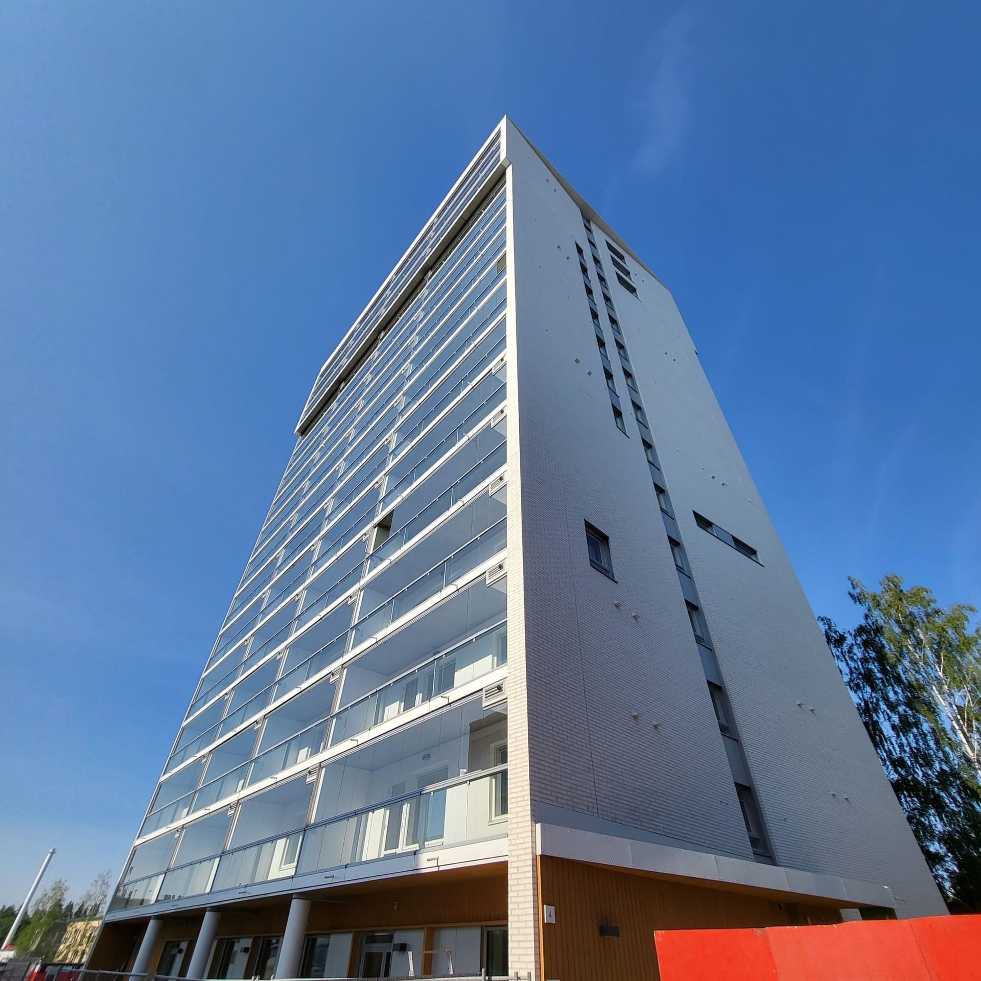 Vaalea julkisivupellitys ja kapeiden ikkunoiden tarkat suojapellitykset peltisepän työnä.