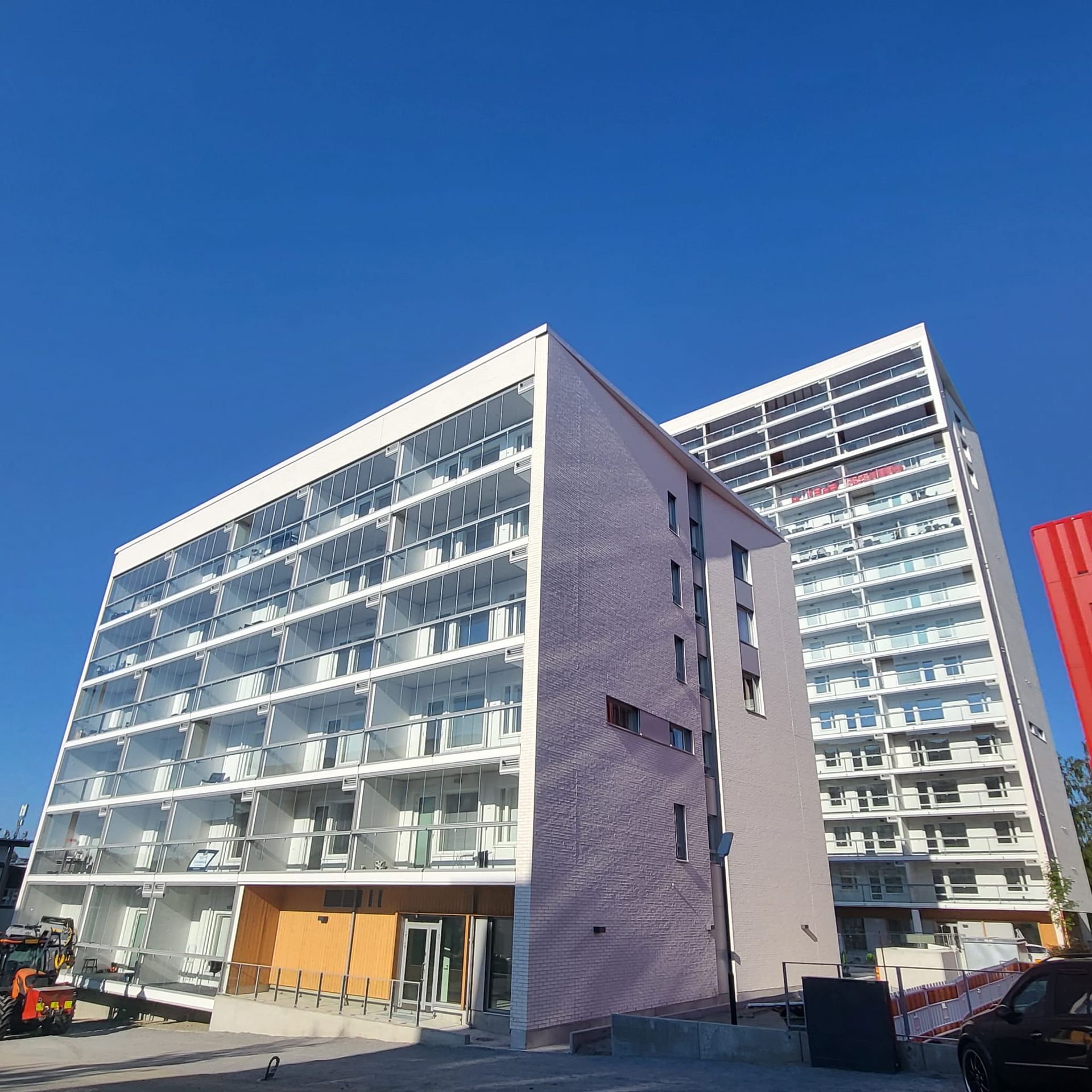 Korkean asuinkerrostalon moderni julkisivupellitys ja parvekkeiden peltisepän työt.