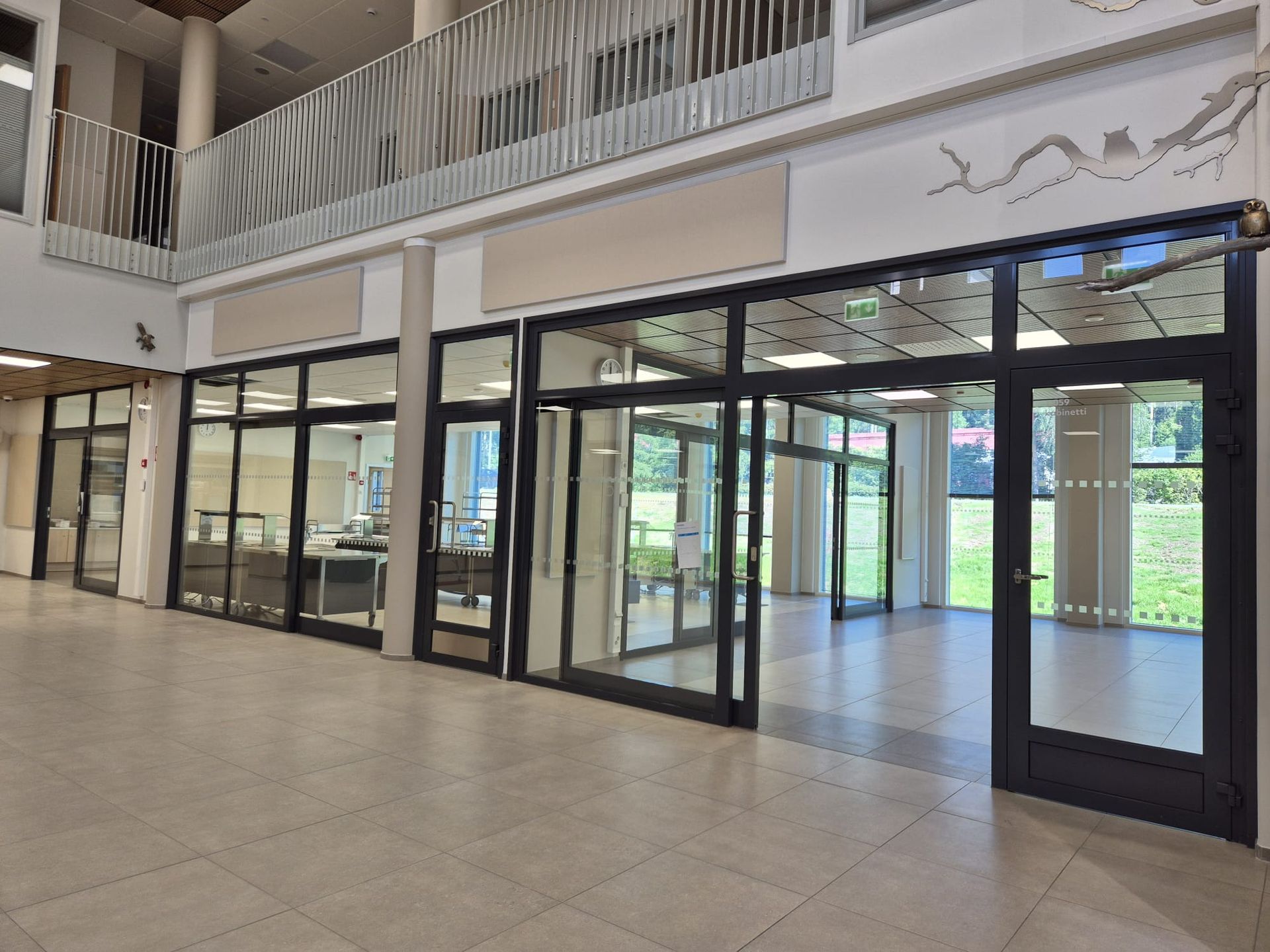 Aulan lasiseinien ja oviaukkojen tarkat listoitus- ja peltityöt sisätiloissa ammattitaidolla.