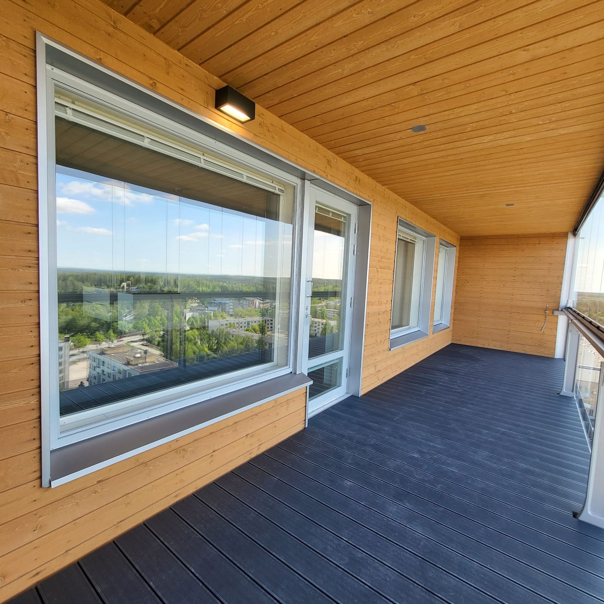 Parvekkeen ikkunapellitykset ja viimeistellyt listoitukset puuverhoillussa modernissa kohteessa.