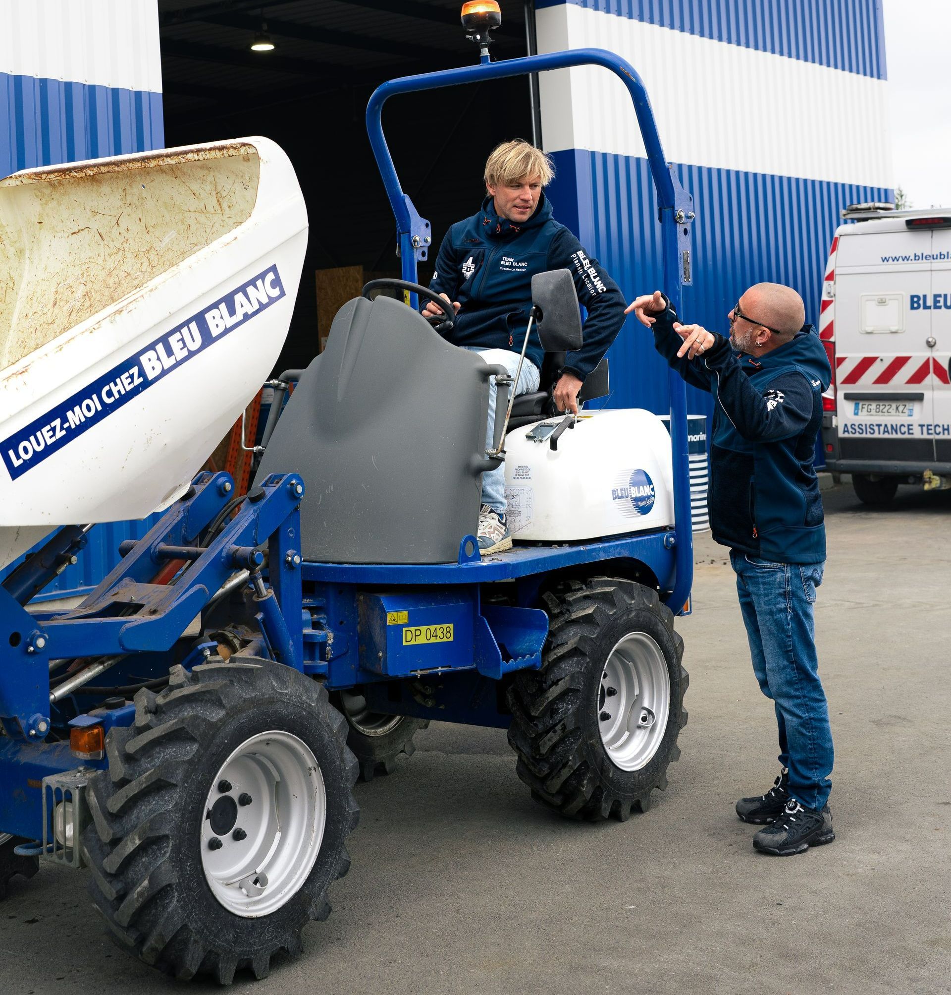 Un homme sur un tractopelle parle avec un autre homme