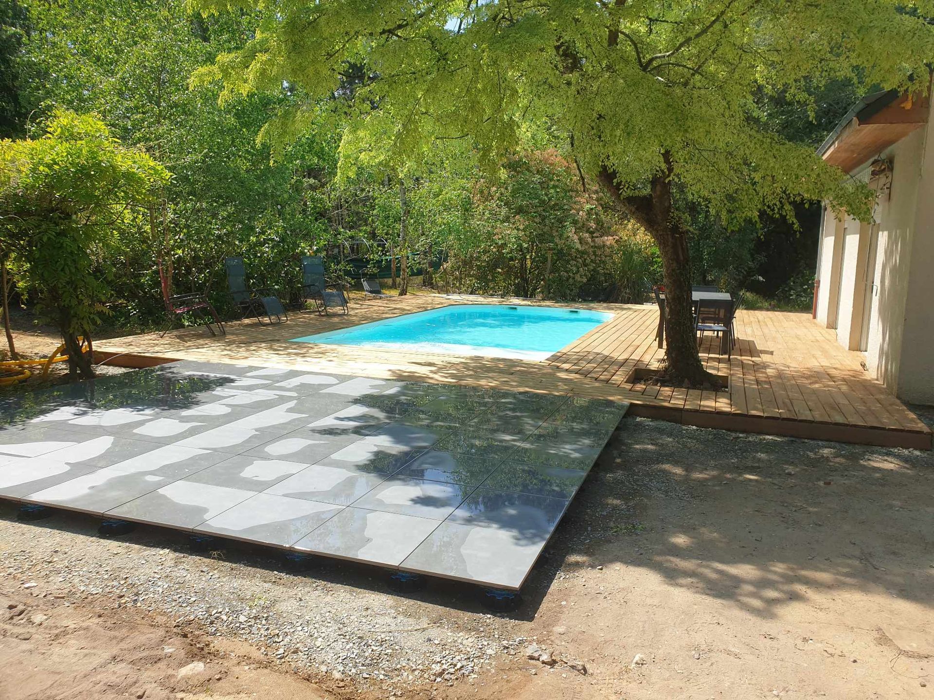 Piscine creusée dans grand terrain arboré.