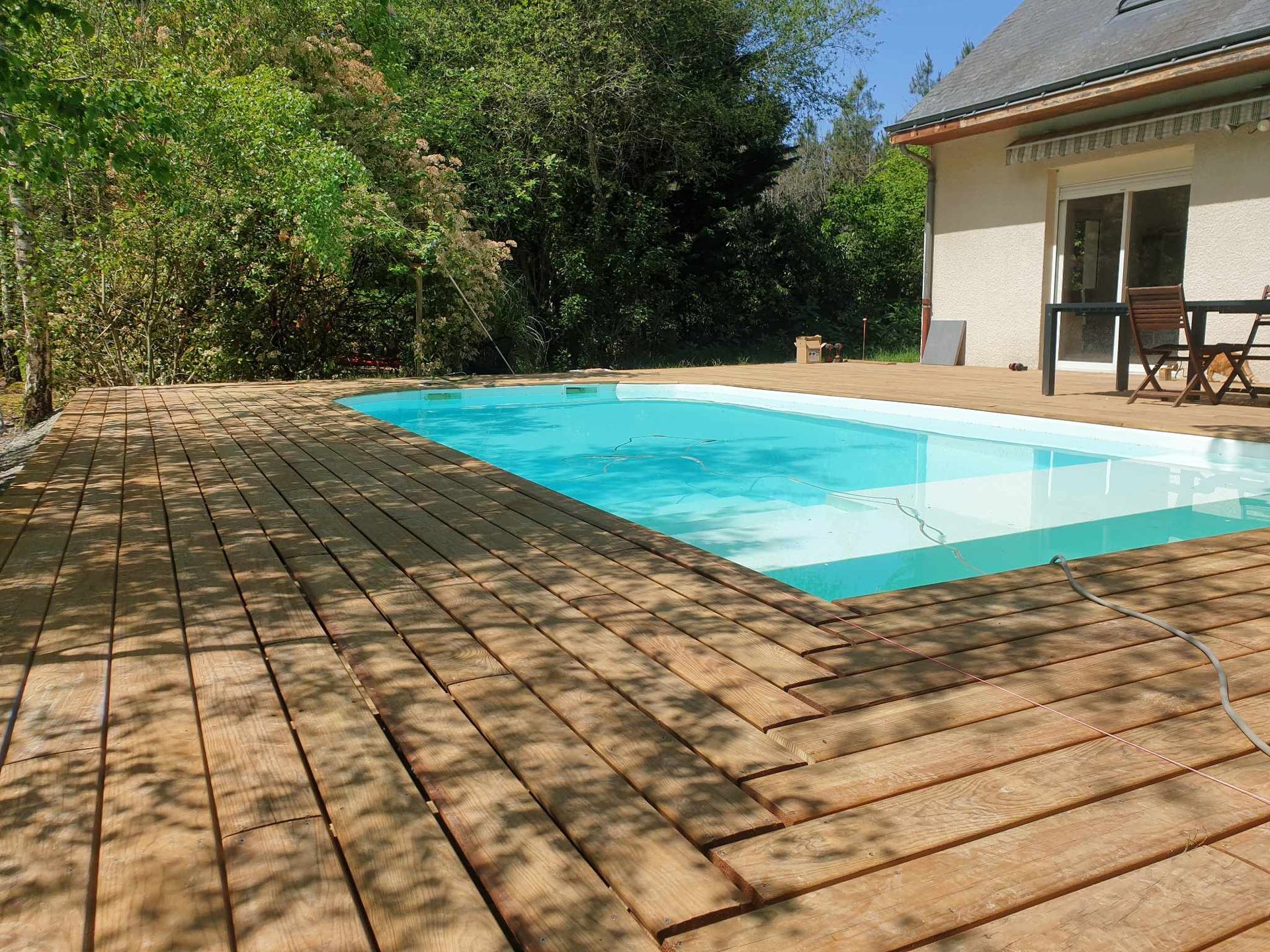Piscine creusée et terrasse en bois.