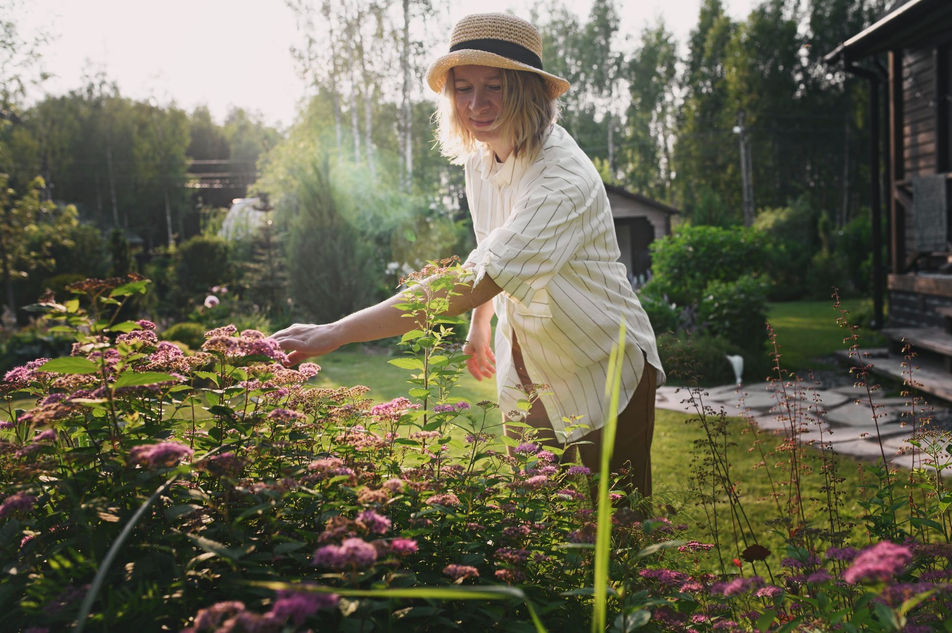 Jeune femme s'occupant d'un parterre de fleurs.