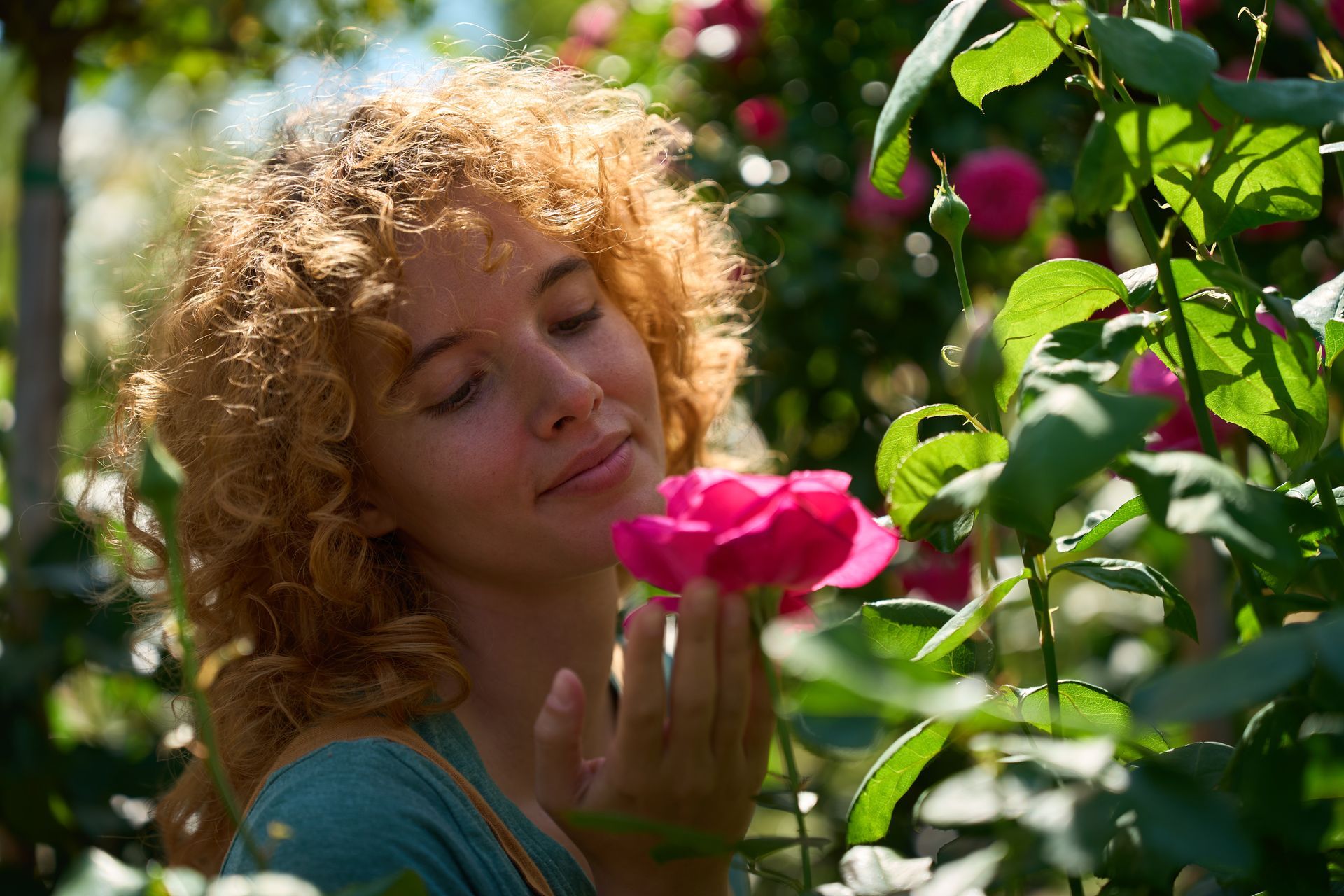 Jeune femme appréciant la senteur d'une rose.