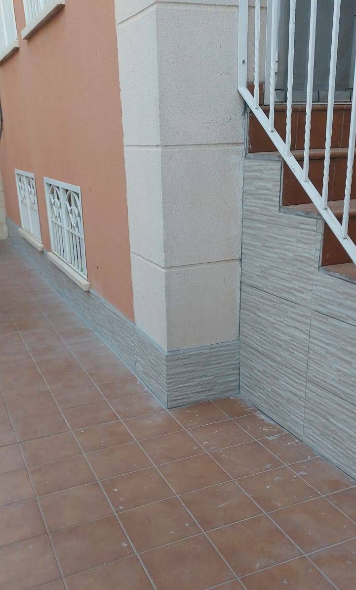 Un hombre está arreglando un interruptor de luz con un destornillador.