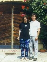 Ein Mann und eine Frau posieren vor einer Holztür für ein Foto.