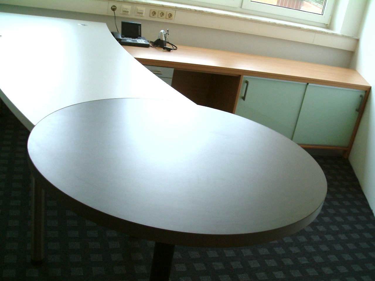 Abgerundeter Schreibtisch mit rund abgesetztem Tisch am Ende