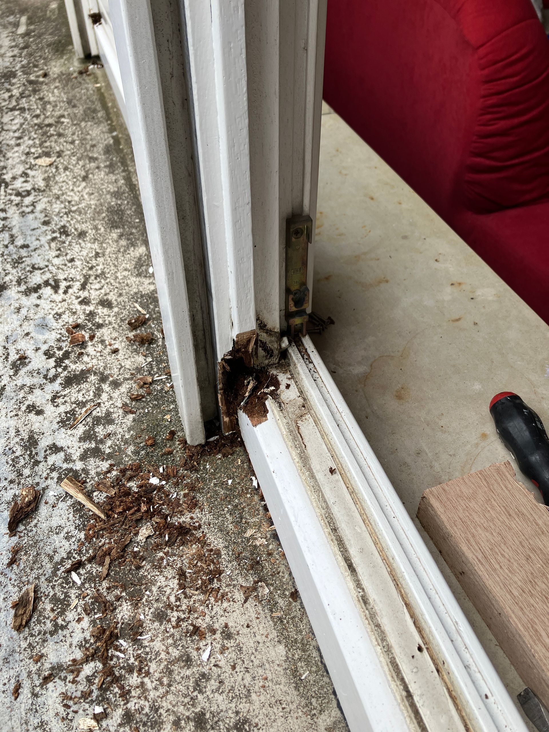 Holzfaeulnis am Fensterrahmen unten mit herausgebrochenem rottendem Holz und Holzspaenen vor der Reparatur
