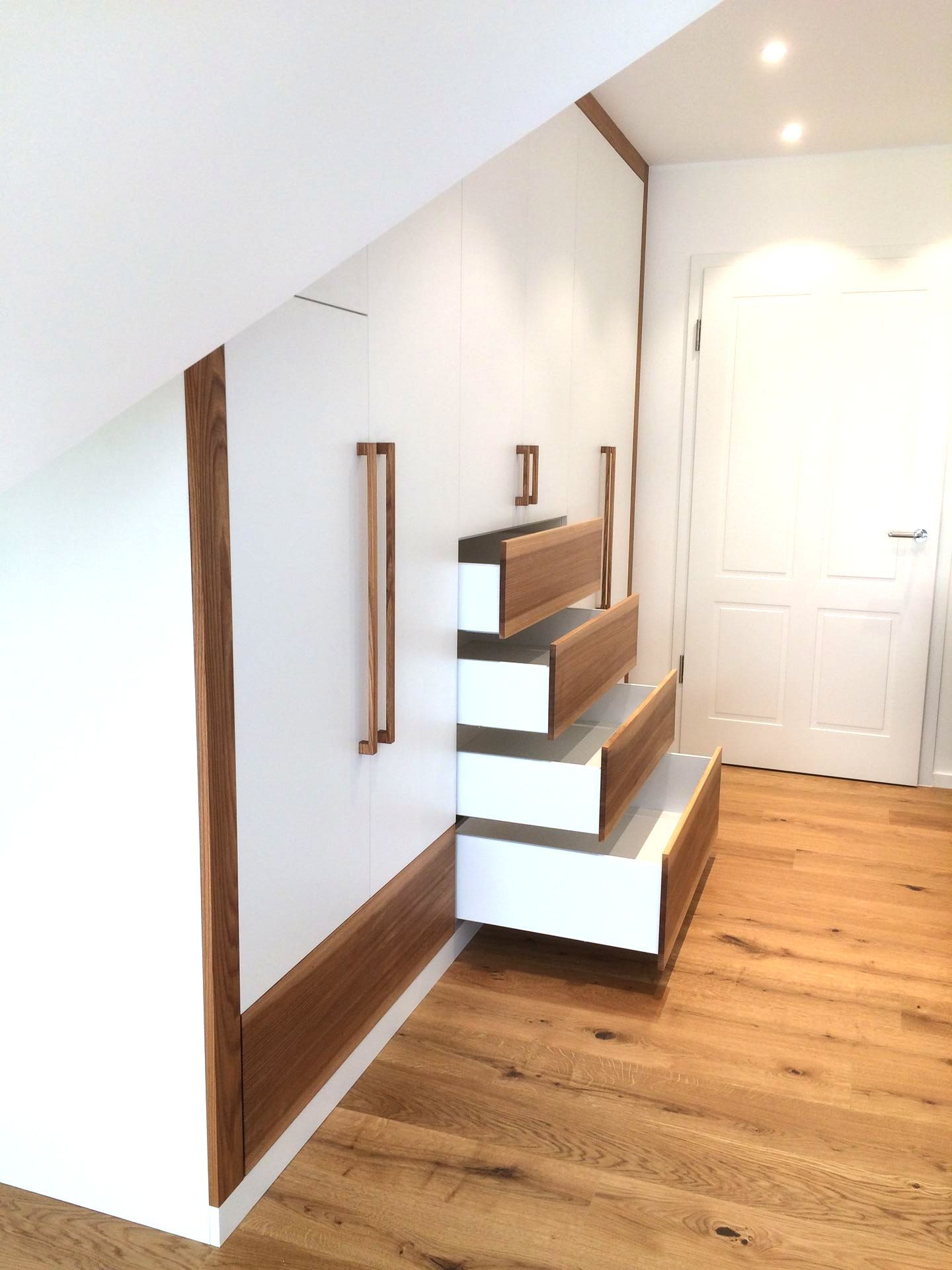 Weißer Einbauschrank mit Holzelementen, geöffnete Schubladen