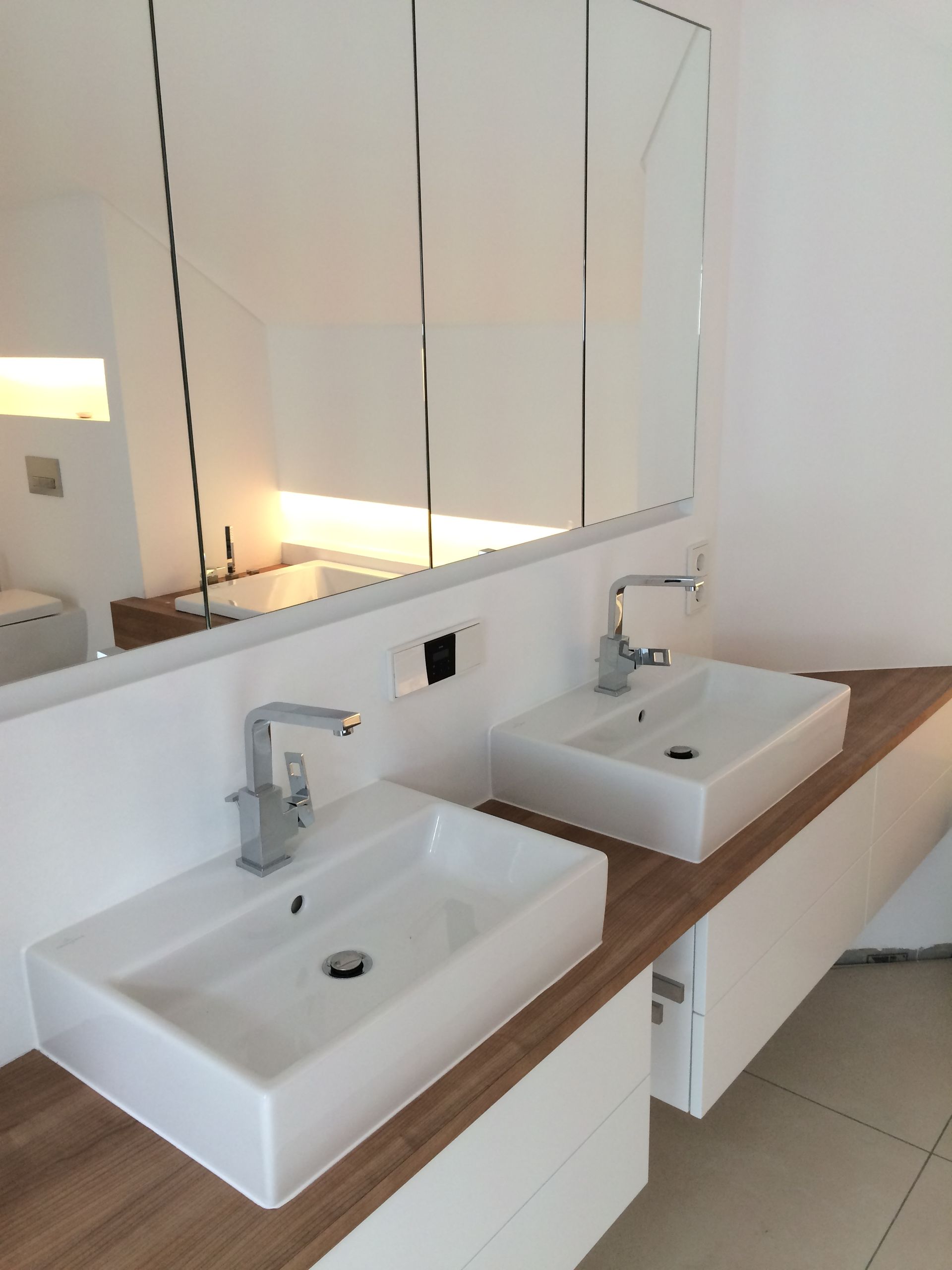 Holz-Waschtisch mit zwei weißen Waschbecken darauf